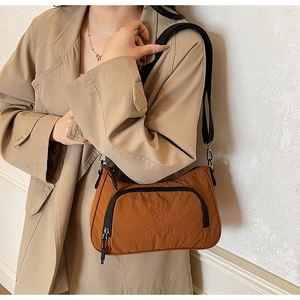 Detail of vintage brown nylon shoulder bag with embroidery and black zip pocket