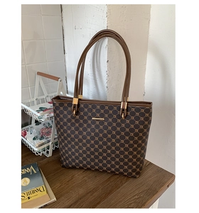 Detailed shot of brown vintage honeycomb pattern tote bag on a wooden table surface