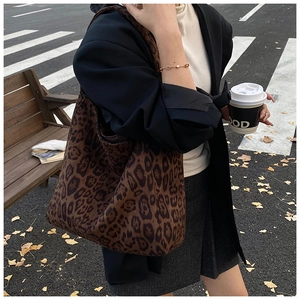 Close-up of leopard print tote bag in autumn street setting with fallen leaves