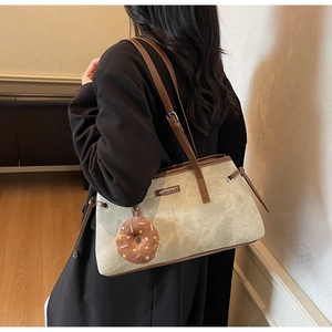 Dettaglio borsa shopper con motivo marmo verde, tracolla in pelle e charm donut peluche
