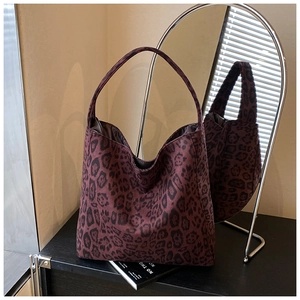 Detailed view of red leopard print tote bag with thick handles on a magazine