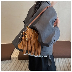Détail du sac bandoulière bohème en daim marron avec de longues franges et rivets