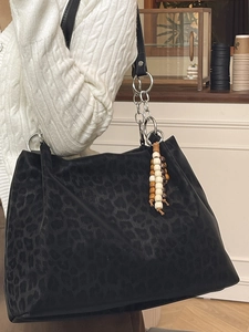 Large black leopard print tote bag with metal chain strap and decorative beads