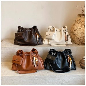 Detail of four chic leather shoulder bags with metal drawstring and wooden beads