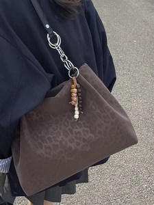 Brown leopard print tote bag with metal chain strap and ethnic bead charm