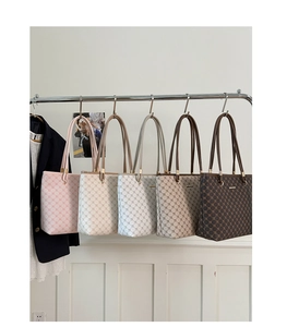 Detailed display of tote bags in five colors featuring geometric logo patterns