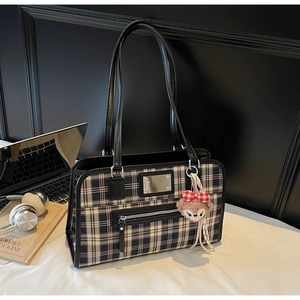 Close-up of classic plaid tote bag with large capacity and stylish metal emblem detail