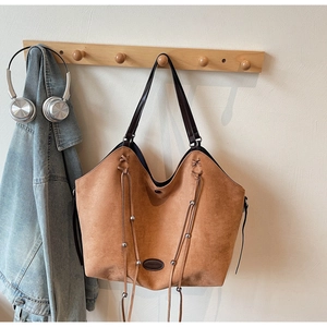 Detail der karamellbraunen Wildleder-Tote Bag mit geflochtenem Kordelzug und Metallperlen