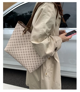 Beige tote bag with geometric patterns worn by a model in a khaki trench coat