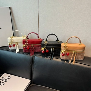 Detailed view of tweed and leather handbags in four colors with cherry charms