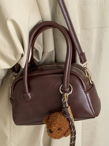 Retro dark brown leather bowling handbag with plush bear charm and crossbody strap
