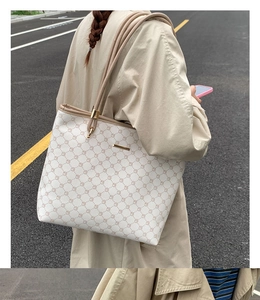 Outdoor street view of a large tote bag with geometric patterns and beige leather straps
