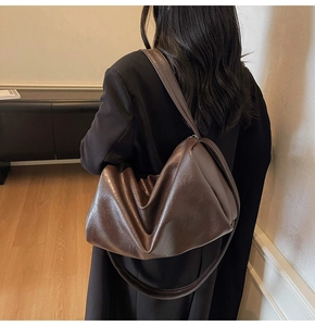 Détail du sac hobo marron foncé souple avec texture en cuir PU plissé sur une bandoulière