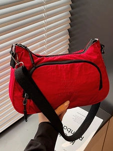 Modern red nylon crossbody bag with black strap and elegant embroidery details