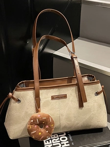 Borsa a spalla in pelle scamosciata beige con tracolla marrone e ciondolo ciambella