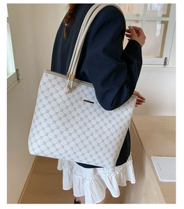 Detailed side view of large tote bag with grey geometric pattern and gold hardware