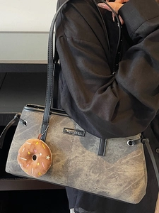 Elegante borsa tote grigia testurizzata con finitura vintage e ciondolo a ciambella