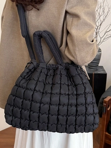 Fashionable black quilted puffer tote bag with adjustable drawstring and wide handle