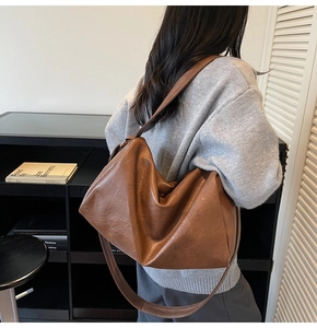 Gros plan du sac cabas en cuir marron montrant sa texture souple et sa large bandoulière