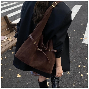 Detailed view of dark brown suede hobo tote bag with gold metal hardware and leather straps