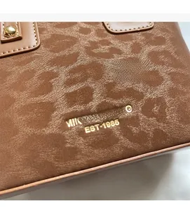 Détail du sac seau léopard avec logo doré de la marque et clous métalliques dorés