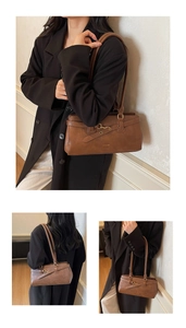 Detail view of brown vintage PU leather baguette bag with metal buckle and long handle