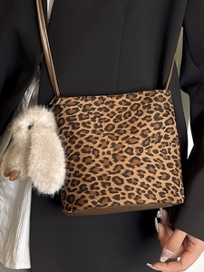 Chic leopard print crossbody bucket bag with a cute plush bunny charm and leather strap