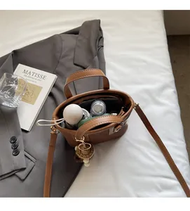 Vue de dessus d'un mini sac seau marron montrant un intérieur spacieux avec accessoires