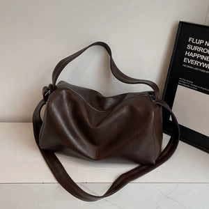 Vue détaillée de la texture en similicuir marron et du design minimaliste du sac demi-lune