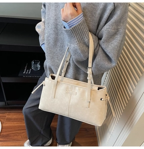 Detail of cream leather tote bag with adjustable shoulder strap and side drawstring