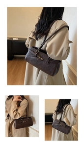 Detail of dark brown vintage faux leather shoulder bag with metallic buckle and dual straps