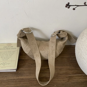 Detailed macro view of the light brown suede shoulder bag with silver metal ring buckle
