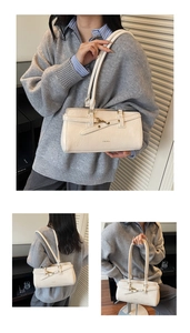 Detailed close-up showing the metallic buckle and stitching on the beige Boston bag