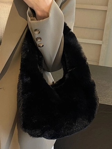 Sac à main chic en fausse fourrure noire porté par un mannequin dans un décor épuré