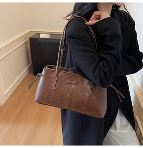 Detailed view of the dark brown leather texture and metal brand tag on the leopard tote