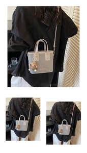 Détail du sac seau gris avec logo embossé et charmant petit monstre en peluche marron