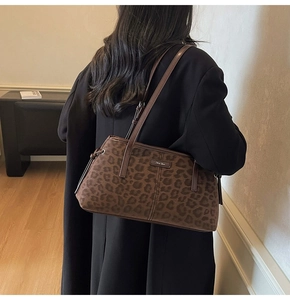 Brown leopard print tote bag shown on shoulder, featuring suede texture and metal logo