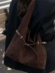Minimalist large brown suede tote bag for women worn by a model in an urban city street