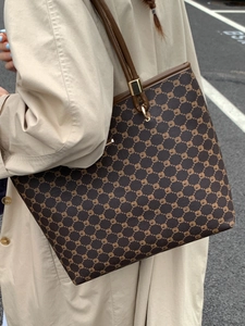 Minimalist large tote bag with brown geometric pattern worn with a beige trench coat