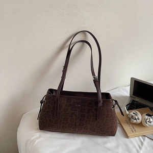 Detailed macro view of vintage leopard print tote with side drawstrings and brown straps