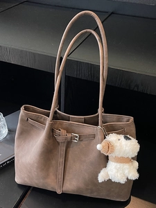 Minimalist vintage brown tote bag with buckle detail and white plush puppy charm