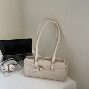Detail of cream white rectangular leather shoulder bag with brass hook and dual straps
