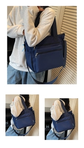 Detail view of the deep blue nylon tote bag with multiple zipper pockets and shoulder strap