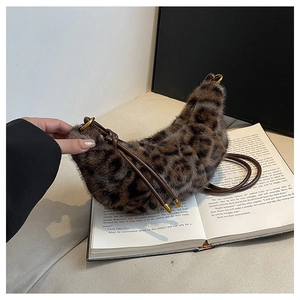 Vue détaillée du sac croissant en peluche léopard avec bandoulière en cuir et boucles dorées
