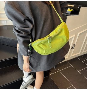 Detail van limoengroene halve maan crossbodytas met verstelbare riem en hanger