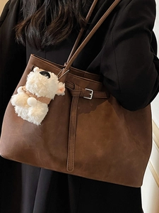 Minimalist deep brown matte tote bag with shoulder strap and cute plush bear accessory
