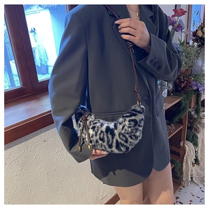 Détail du sac croissant en peluche léopard avec bandoulière en cuir et nœuds