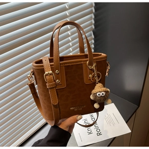 Détail du mini sac cabas en daim léopard caramel avec charmant pendentif en peluche