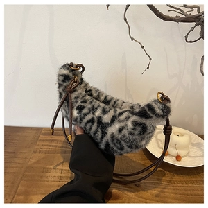 Détail du sac croissant en fausse fourrure léopard avec bandoulière en cuir marron