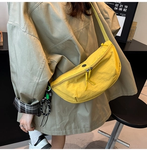 Close-up van heldergele nylon halve maan crossbodytas met dubbele ritssluitingen
